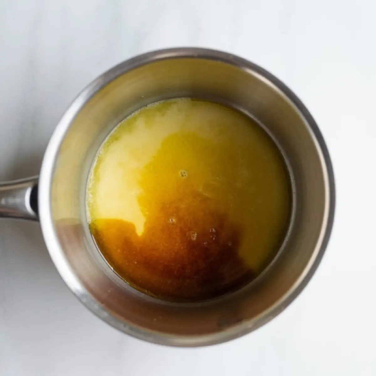 Stacked churro rice krispie treat squares on a white plate with cinnamon sugar topping, photographed on a marble background with churro rice krispie treats text overlay.
