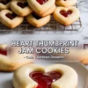 Pinterest collage with heart-shaped thumbprint cookies stacked on a wire rack in the top frame, and a close-up of a bitten cookie on a plate in the bottom frame, with overlay text “Heart Thumbprint Jam Cookies – Cute Valentines Desserts.”