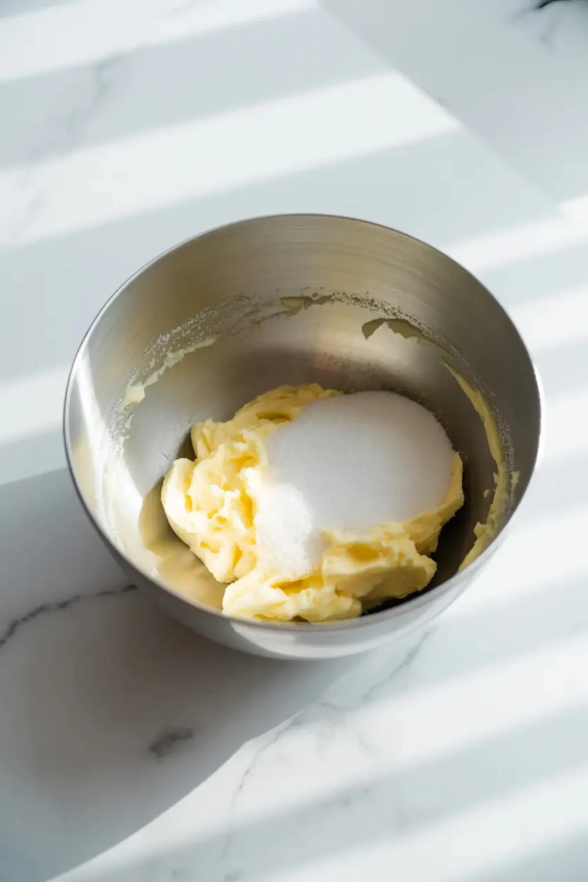 Butter and sugar sit in a mixing bowl at the start of making the vanilla cake batter for berry chantilly cake.