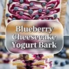 Blueberries simmering in a small saucepan for the swirl topping on blueberry cheesecake yogurt bark.