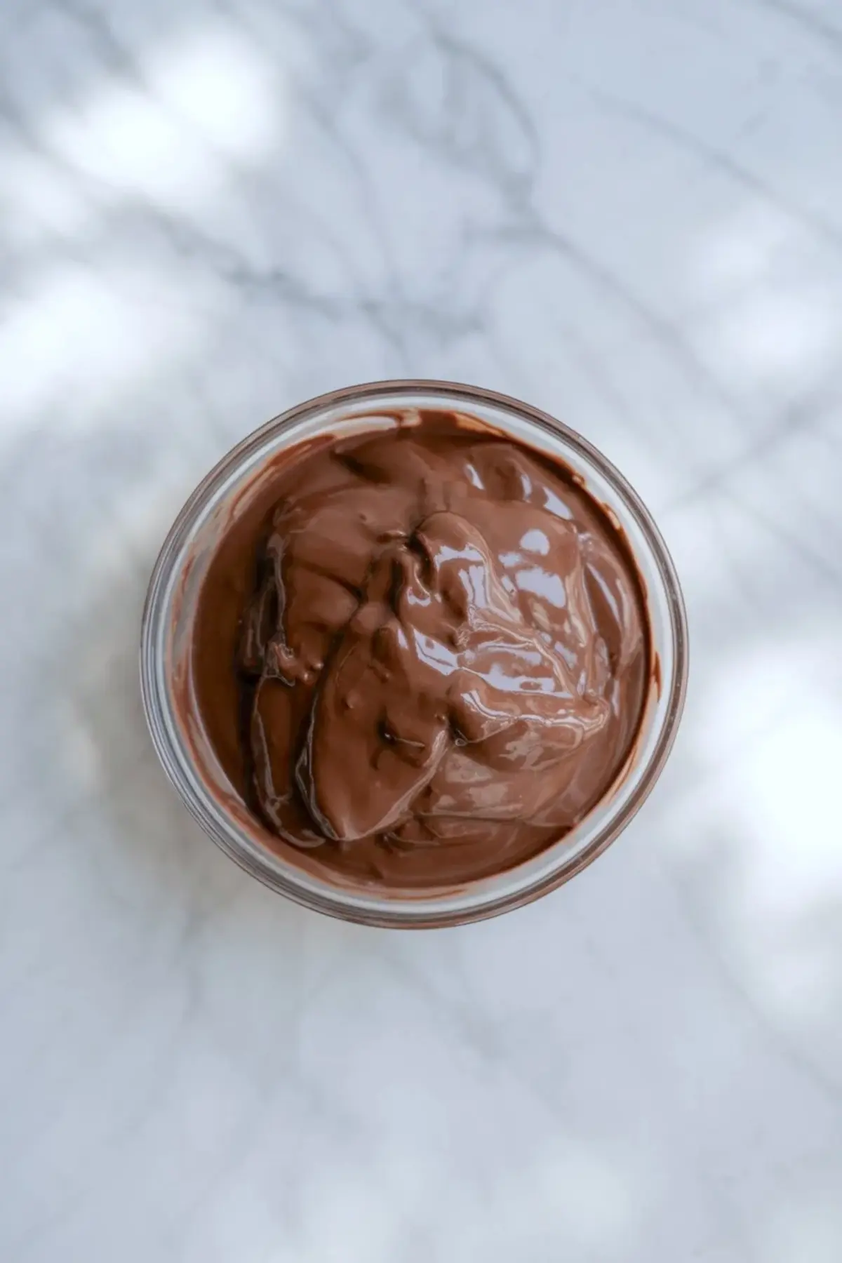 Chocolate yogurt mixture in a glass bowl for chocolate yogurt parfait before layering.