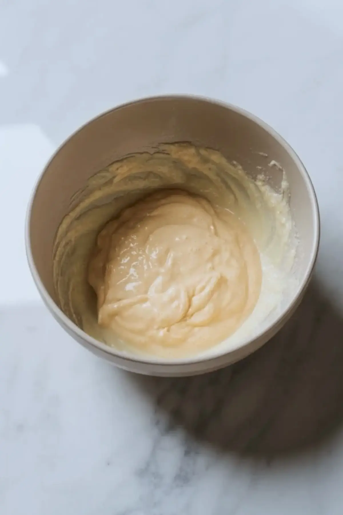 Cooked custard base in a bowl for grape ice cream, showing the thick creamy mixture before churning.