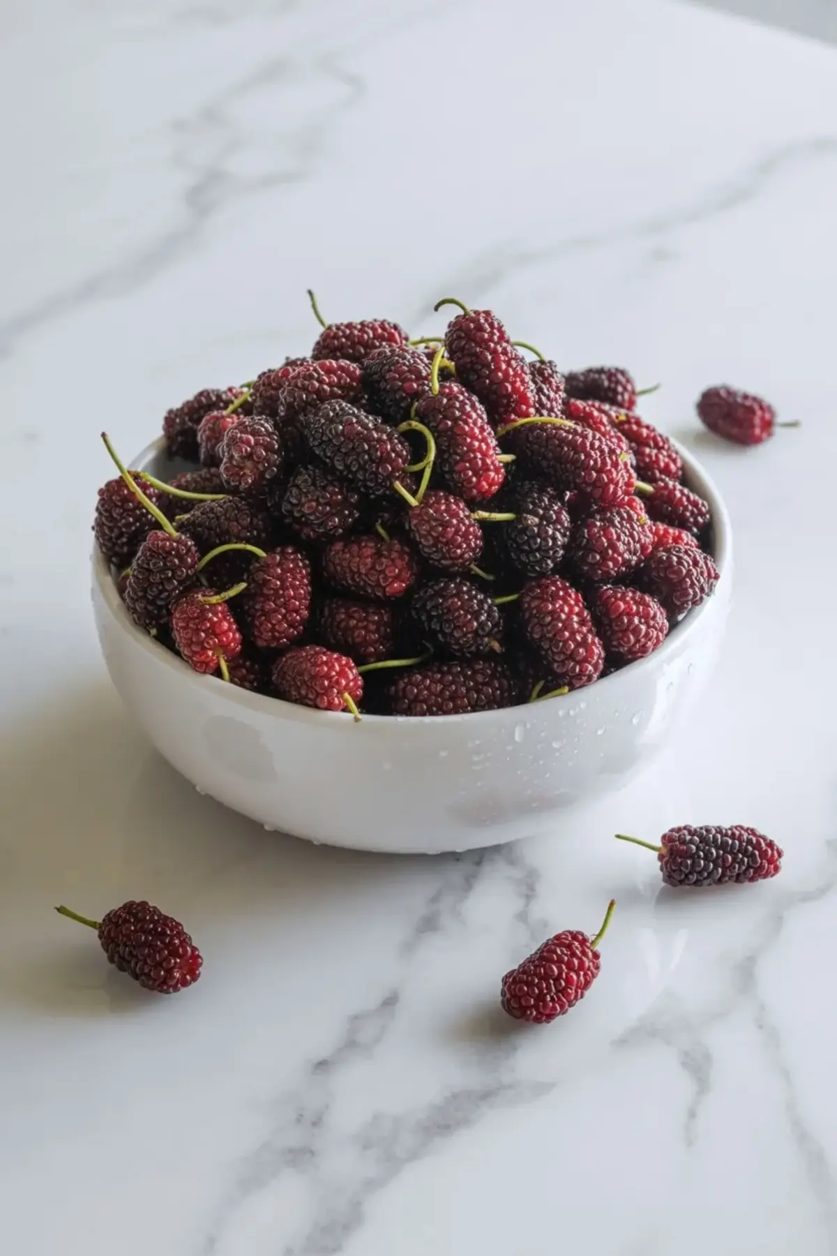 Fresh mulberries cook in a saucepan as the fruit softens and releases juice for this homemade mulberry jam recipe and berry preserve.