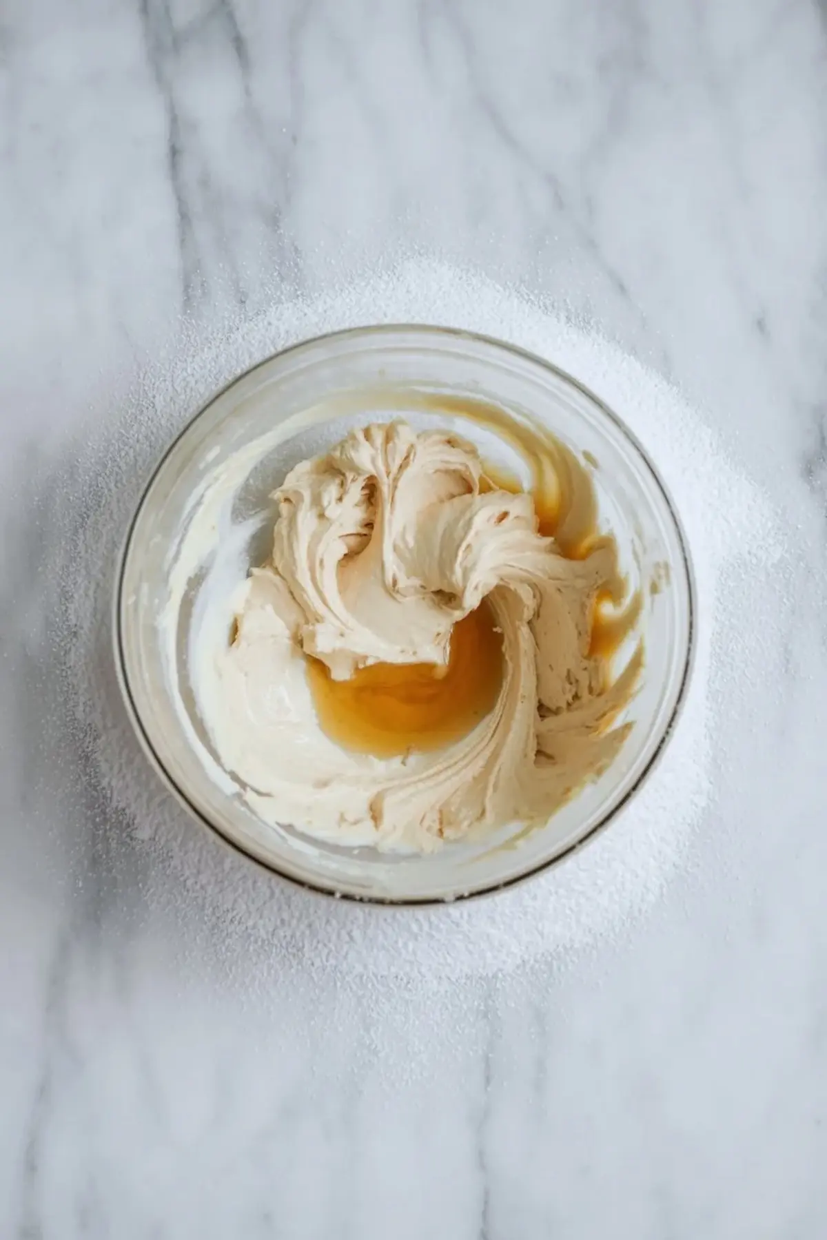 Cream cheese mixture for strawberry cheesecake fluff whipped in a glass bowl before the whipped topping is folded in.