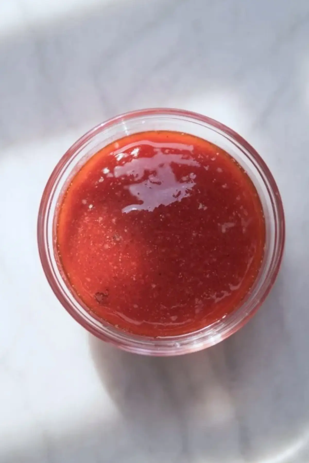 Fresh strawberry topping in a glass bowl for strawberry coconut no-bake cheesecake bars.