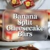 Featured image for banana split cheesecake bars showing sliced bars with banana, strawberry topping, and chocolate drizzle.