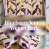 Blueberry lemon yogurt bark featured image with text overlay showing a tray of swirled yogurt bark and cut squares topped with blueberries and lemon zest.