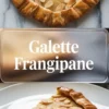 Galette frangipane shown in a 2 to 3 hero image with a golden almond galette topped with sliced almonds on a white marble background.