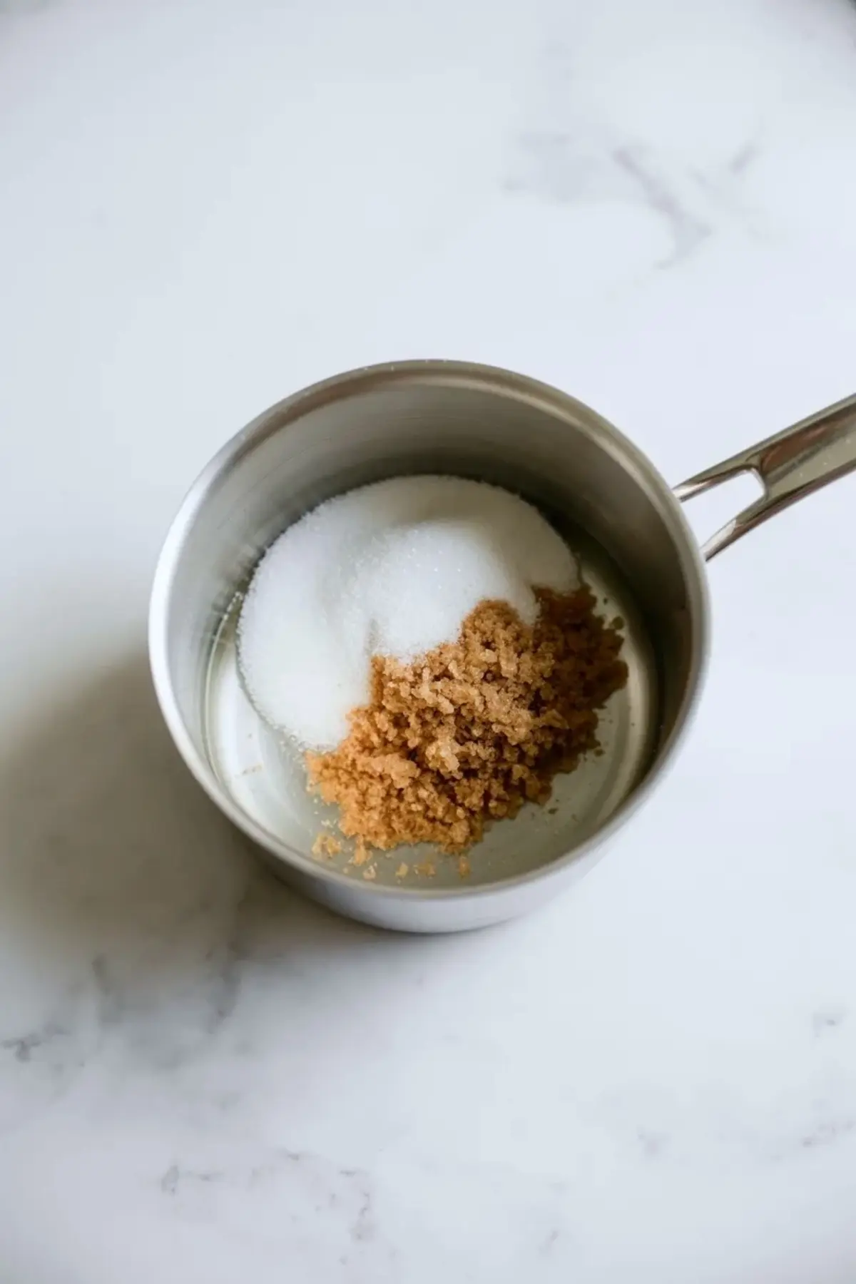 Granulated sugar and brown sugar in a saucepan ready to be heated for homemade amaretto syrup.