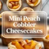 Mini peach cobbler cheesecakes on a cooling rack topped with glossy peach slices and small cobbler crumble pieces.