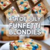 4th of July funfetti blondies cut into bars with red, white, and blue candy pieces, shown stacked on parchment with one blondie on a plate.