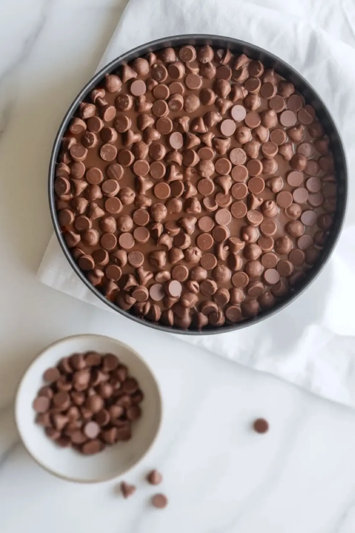 Chocolate chips layered in a baking dish for patriotic s’mores dip before the marshmallows are added.