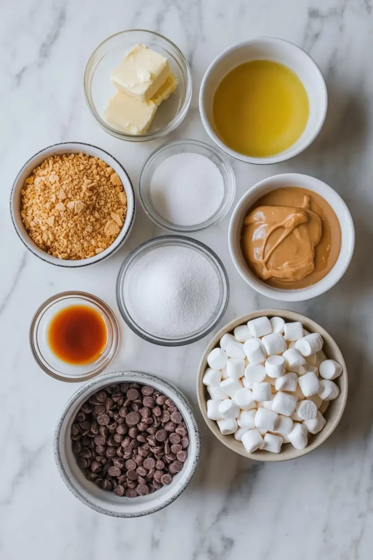 Peanut butter smores bars in the pan topped with a thick layer of mini marshmallows ready to bake.