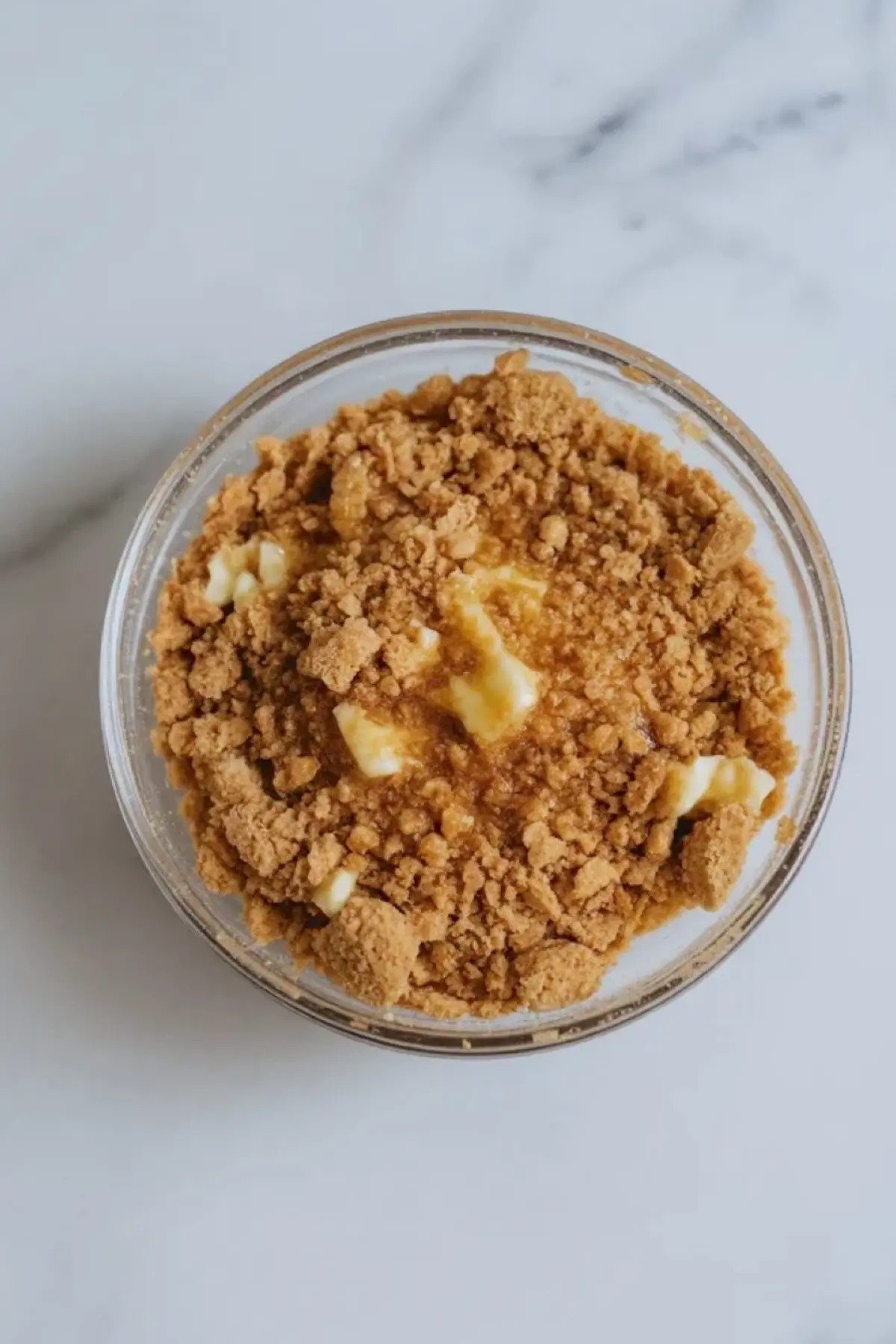Graham crumb base layered into a dessert cup for strawberry ricotta cheesecake cups before the filling is added.