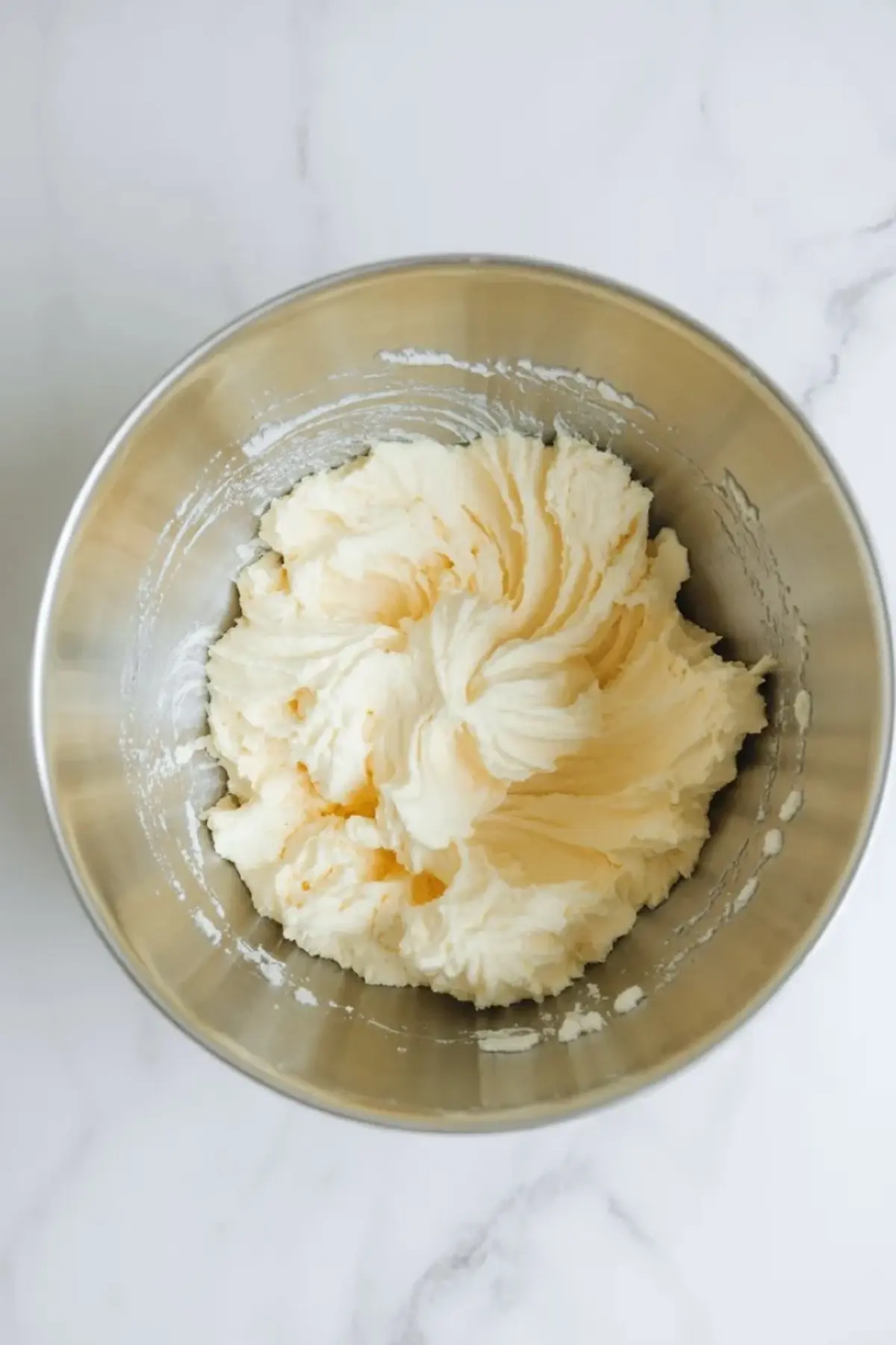 Butter and sugar are beaten together in a mixing bowl to start the batter for American flag cake.