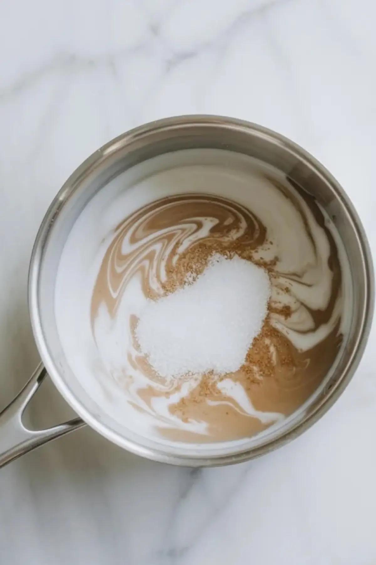 Coconut milk mixture for coconut jelly is stirred in a saucepan with sugar and agar before the dessert sets.