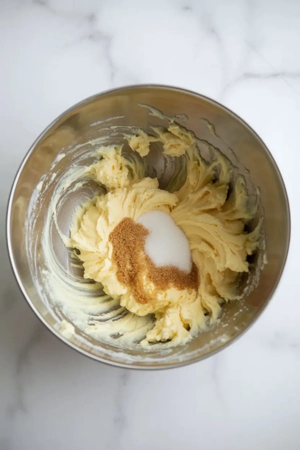 Butter, brown sugar, and granulated sugar are beaten together until creamy for the maple pecan cookies dough base.