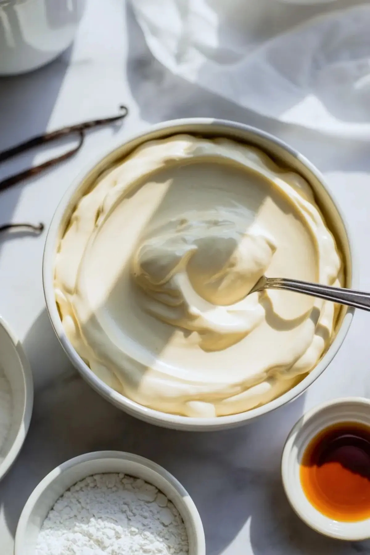 Creamy cheesecake filling for raspberry cheesecake cookies in a bowl with vanilla and powdered sugar mixed until smooth.