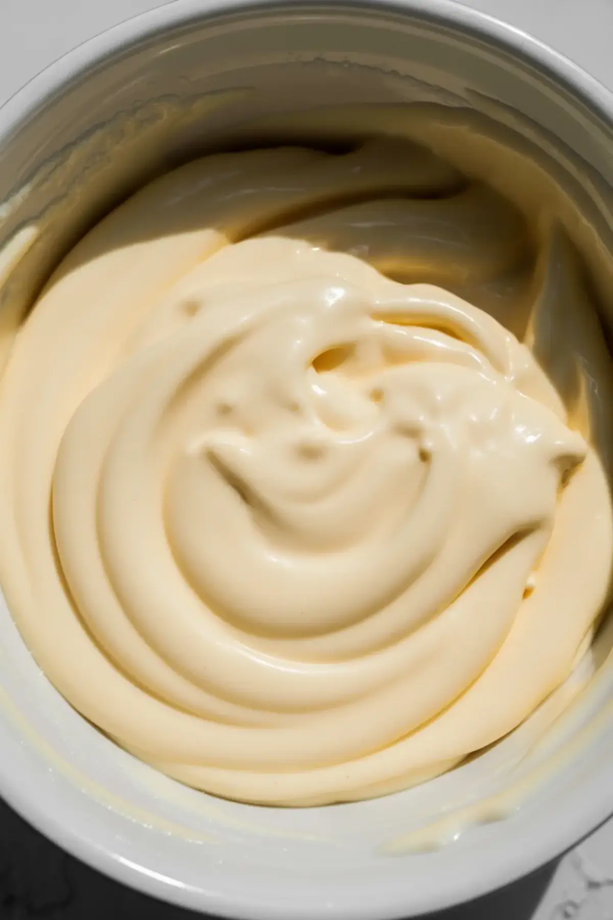 Smooth glossy choux dough ready to pipe for vanilla glazed French crullers.
